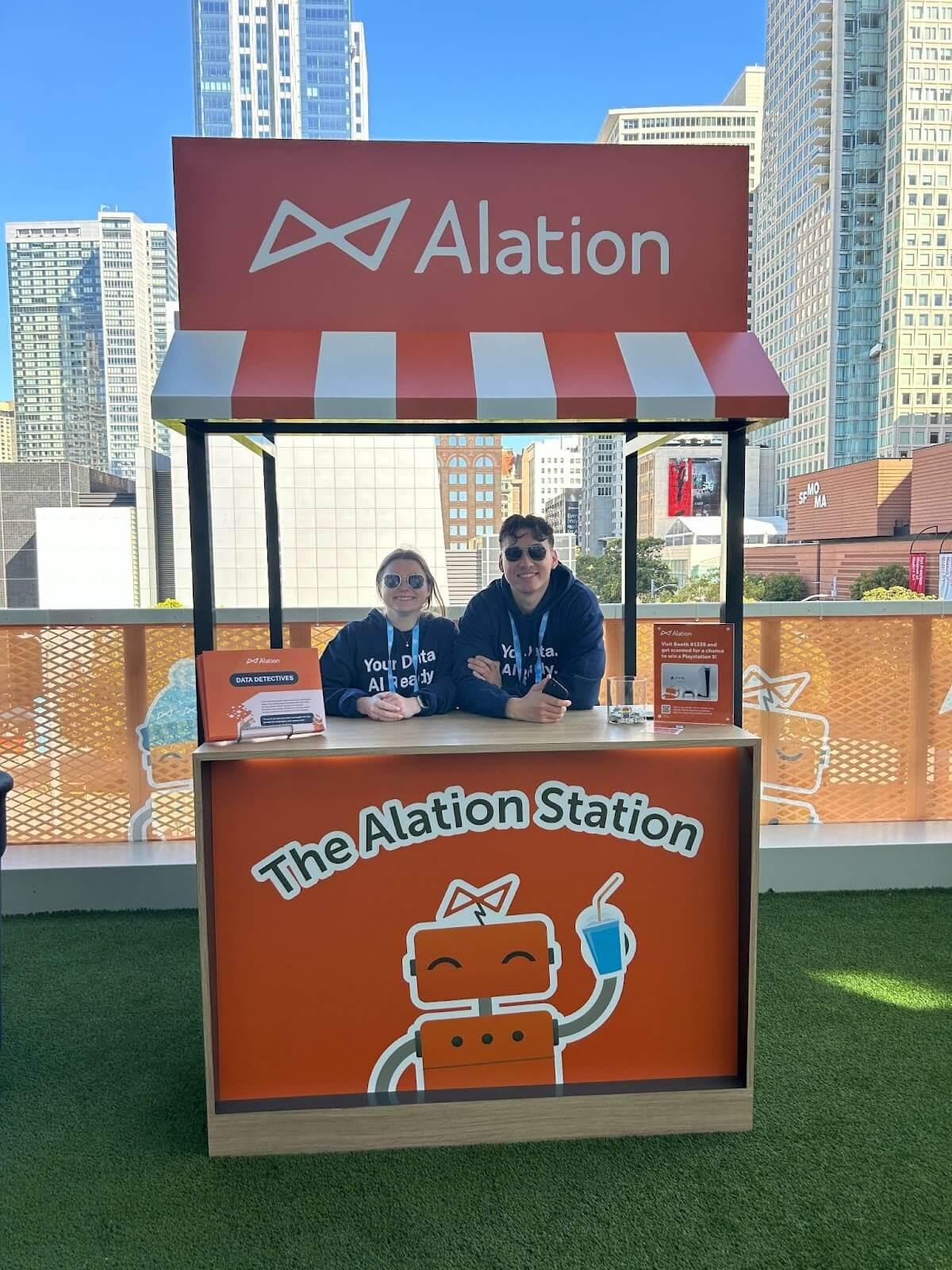 Two Alationauts serving smoothies at the Alation Station at Snowflake Summit 2024.