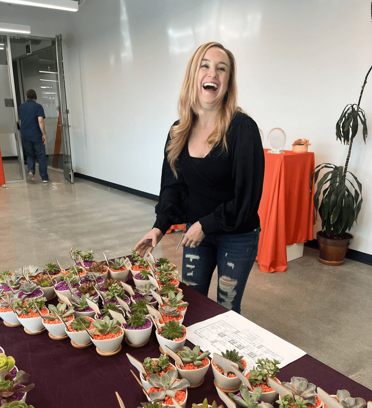 Stephanie Aubrey, Chief of Staff, Office of the CEO, grabs a desk plant at the Return To Office Kickoff party in Redwood City.