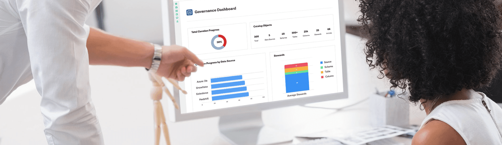 coworker showing female coworker how to deliver data quality with governance on a desktop computer screen in an office setting